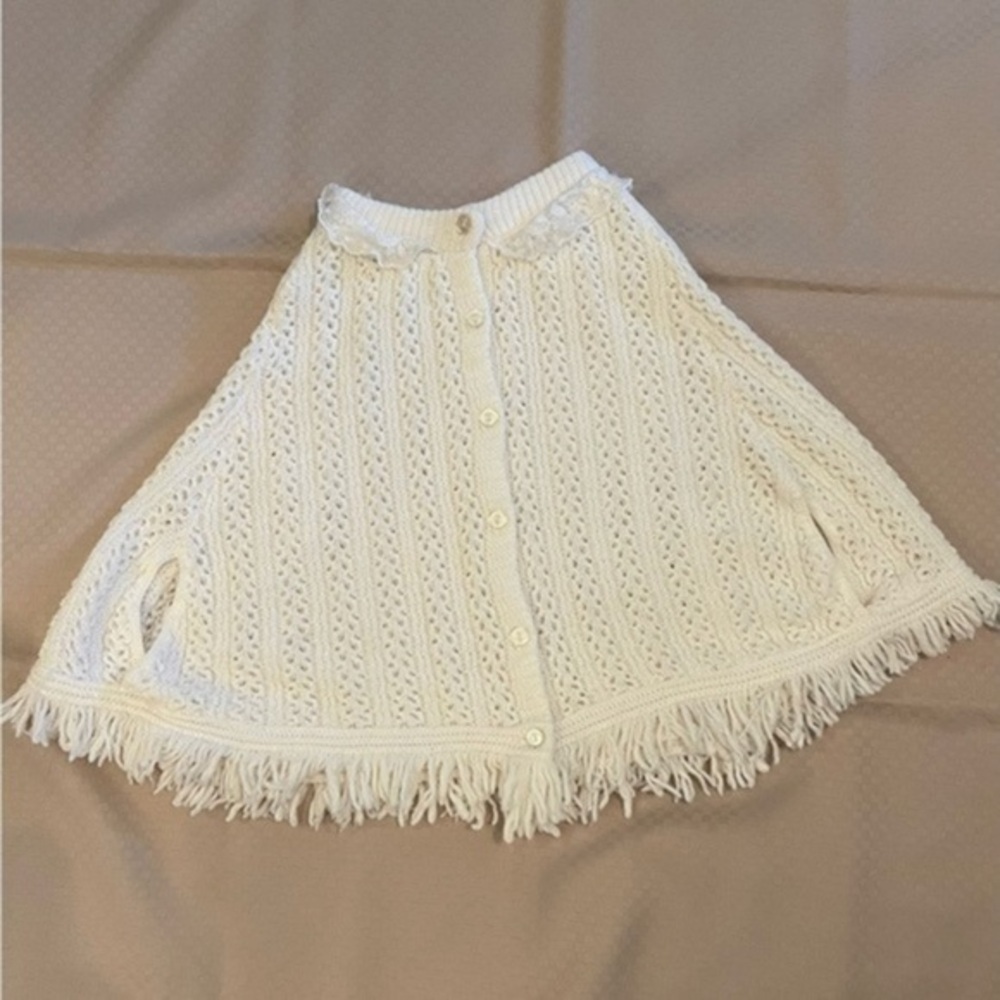 Grand Knitwear vintage acrylic knitted, fringed child’s shawl in ivory.​